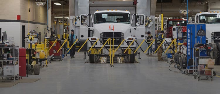 A while Mack MD truck in service station.