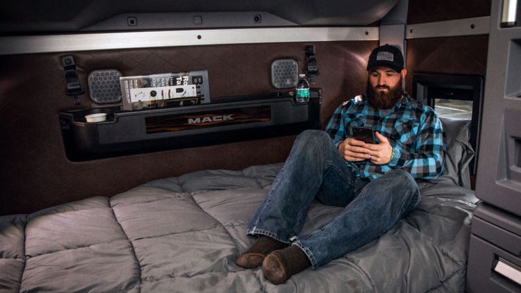 Driver in a spacious cabin for comfort and appliances.