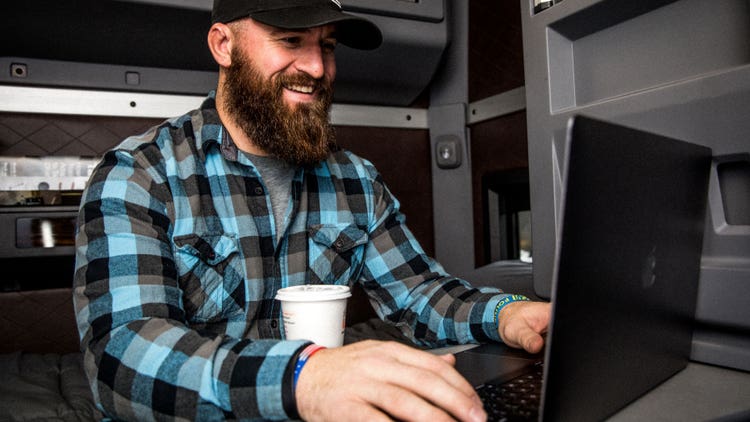 A person enjoying working on a laptop inside the truck’s cabin.